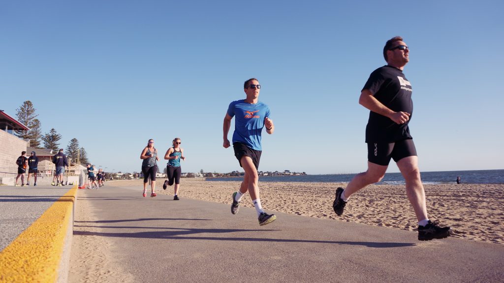 Tri Alliance athletes running along the Elwood Beach path during a Try the Tri run session