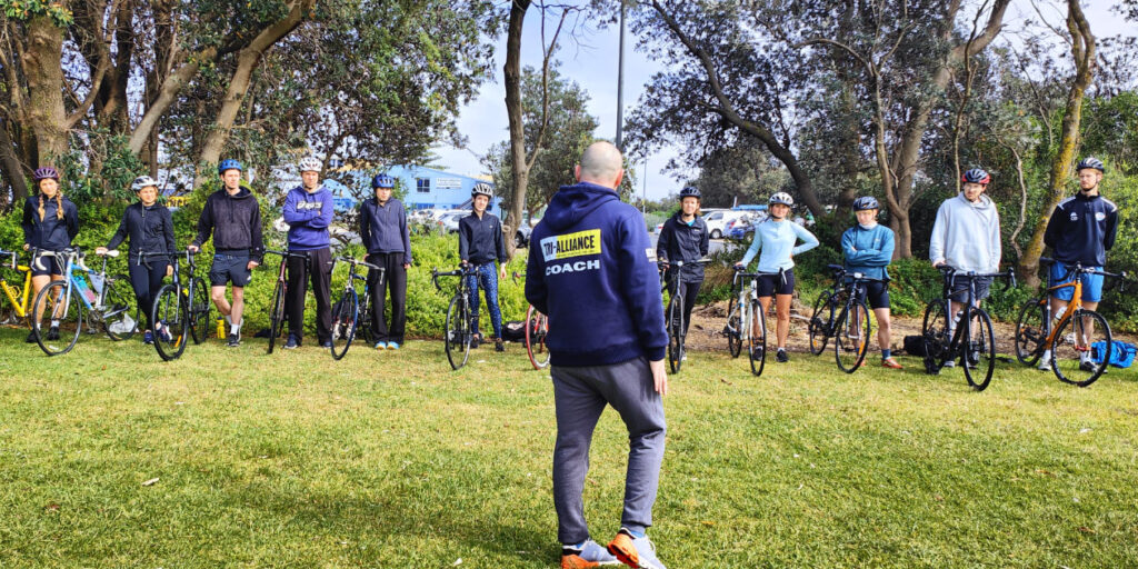 Tri Alliance coach briefing a Try the Tri beginner triathlon group before a bike session