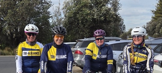 Four Tri Alliance women with their bikes in the carpark